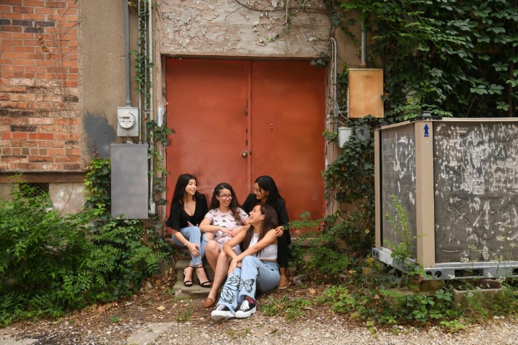 Four Female Latino Students Outside Sitting ATLAST Nonprofit McKinney Texas.